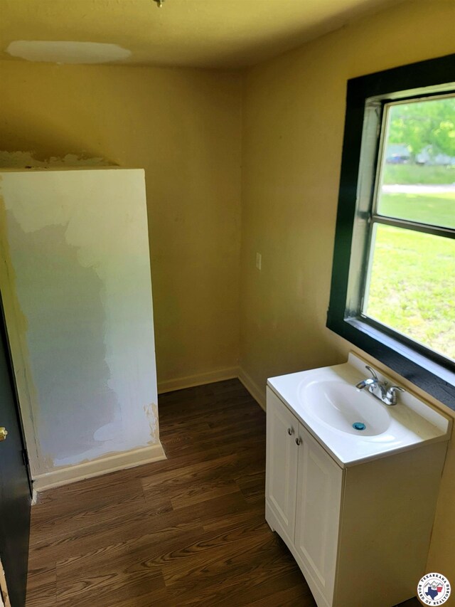 501 S Columbia St, Clarksville, TX 75426 - bathroom with wood finished floors, baseboards, and vanity
