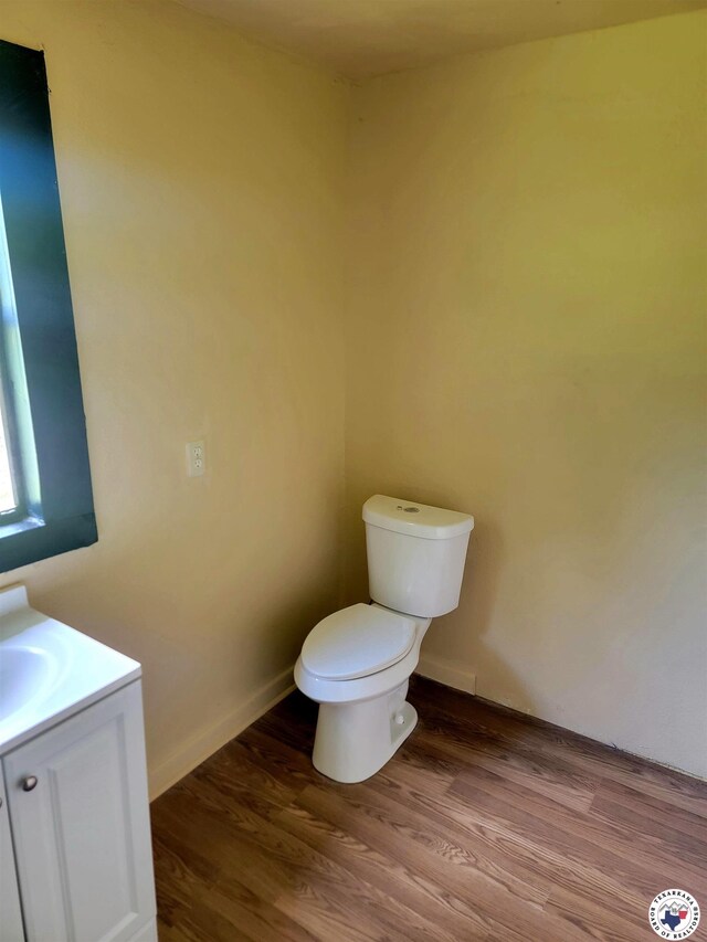 501 S Columbia St, Clarksville, TX 75426 - bathroom featuring toilet, vanity, and wood finished floors
