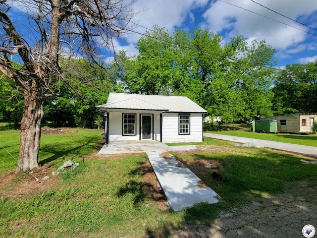 501 S Columbia St, Clarksville, TX 75426 - bungalow-style house featuring a front lawn, metal roof, and covered porch