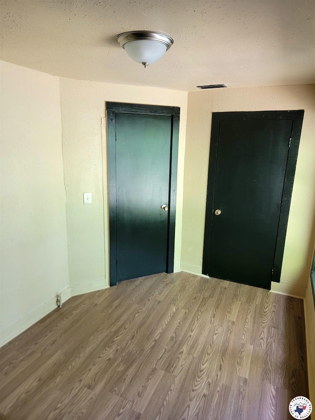 501 S Columbia St, Clarksville, TX 75426 - hallway featuring wood finished floors, baseboards, and a textured ceiling