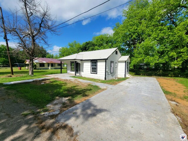 501 S Columbia St, Clarksville, TX 75426 - bungalow featuring a front lawn, metal roof, and driveway