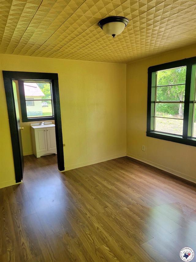 501 S Columbia St, Clarksville, TX 75426 - unfurnished room featuring healthy amount of natural light, dark wood-style flooring, and baseboards