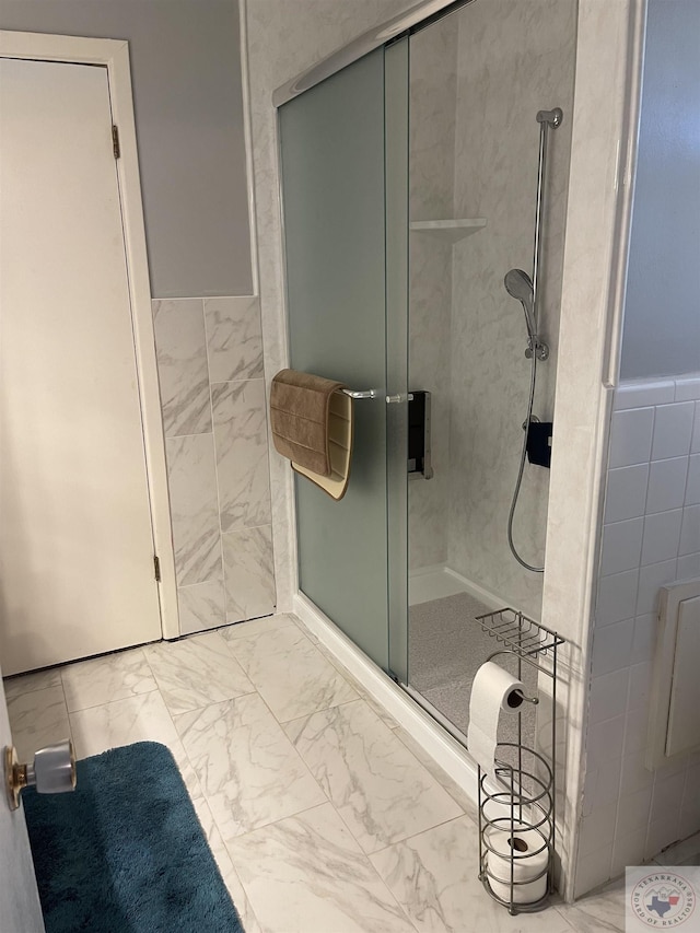 bathroom with a shower with shower door and tile walls