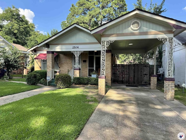 2504 Walnut St, Texarkana, TX 75503 - view of front of property with brick siding, concrete driveway, covered porch, and an attached carport