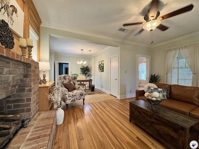 2504 Walnut St, Texarkana, TX 75503 - living room with light wood finished floors, a chandelier, ceiling fan, a textured ceiling, and ornamental molding