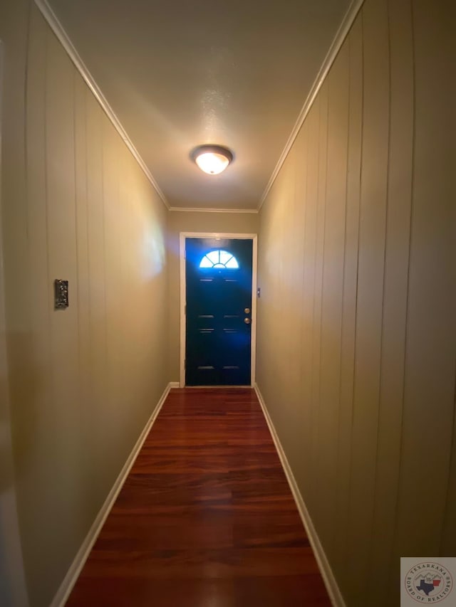 doorway featuring crown molding, wooden walls, and dark hardwood / wood-style floors