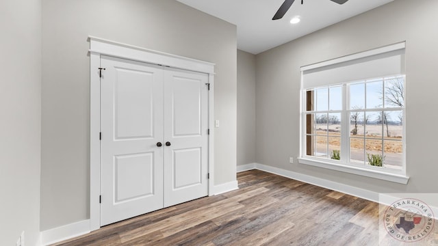 unfurnished bedroom featuring a closet, ceiling fan, and wood-type flooring