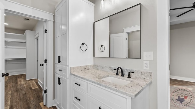 bathroom with wood-type flooring, ceiling fan, and vanity