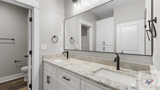 bathroom featuring wood-type flooring, toilet, and vanity