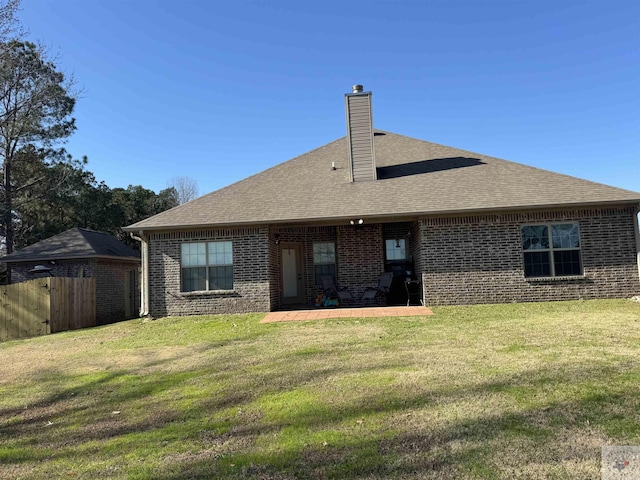 back of property with a patio area and a lawn