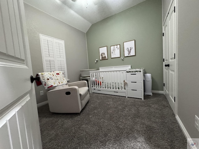 carpeted bedroom with a crib and lofted ceiling