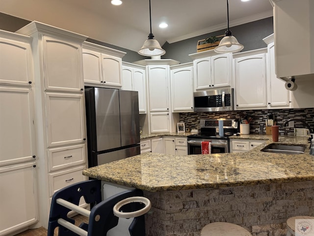 kitchen with light stone counters, sink, pendant lighting, and stainless steel appliances