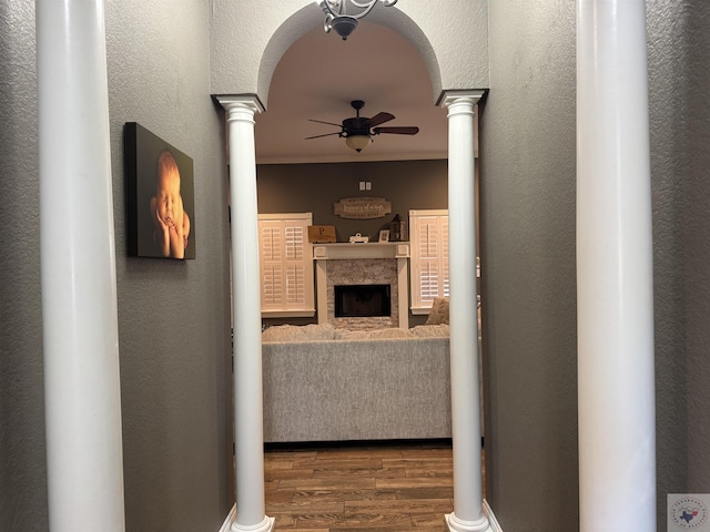 corridor with decorative columns, hardwood / wood-style flooring, and crown molding