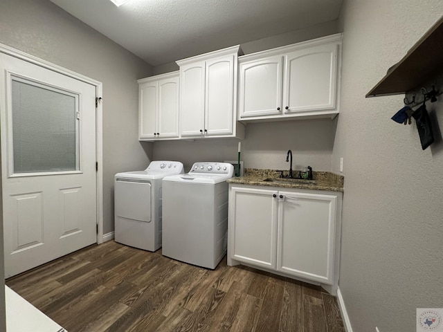 clothes washing area featuring cabinets, sink, washer and dryer, and dark wood-type flooring