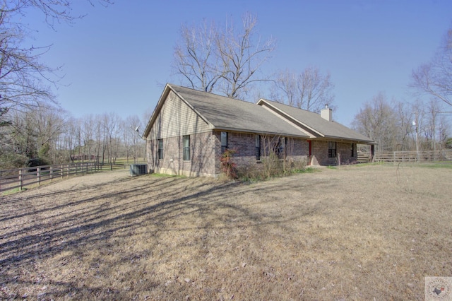 view of home's exterior with central AC unit and a yard