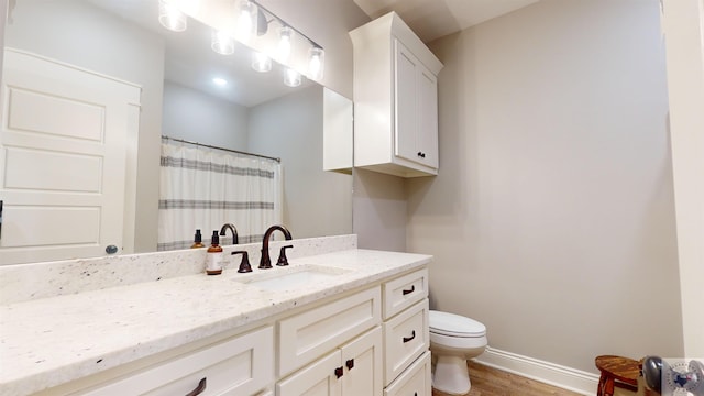 bathroom featuring wood-type flooring, toilet, vanity, and walk in shower