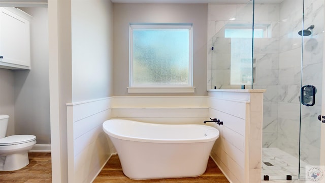 bathroom with hardwood / wood-style floors, toilet, a healthy amount of sunlight, and shower with separate bathtub