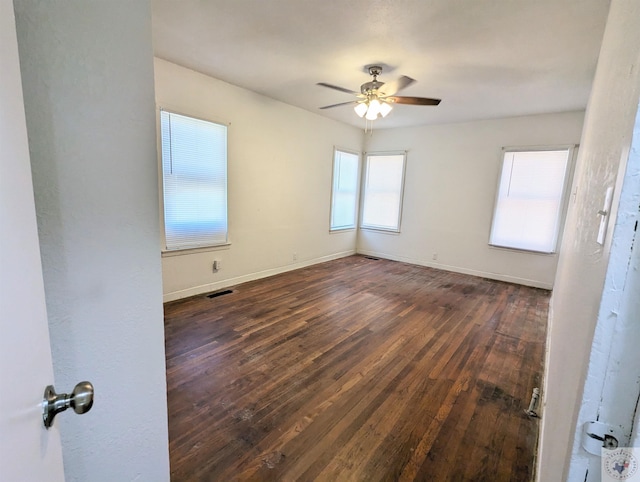 spare room featuring ceiling fan and dark wood-type flooring