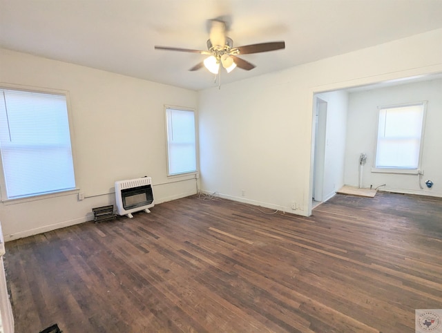 unfurnished room with heating unit, ceiling fan, and dark wood-type flooring