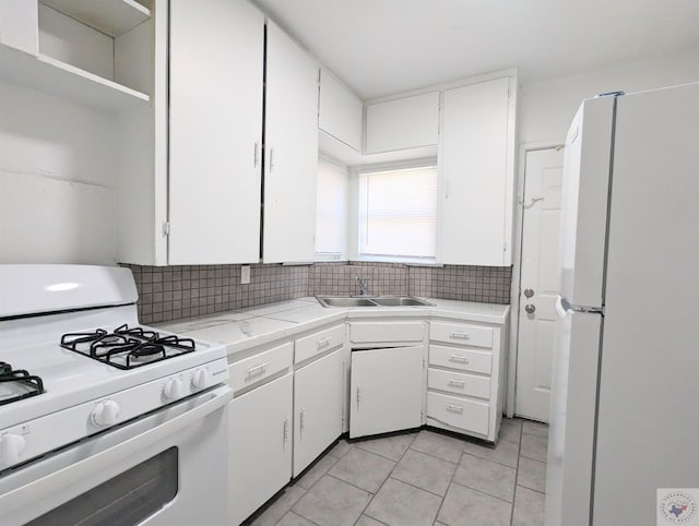 kitchen with sink, backsplash, white cabinets, light tile patterned floors, and white appliances