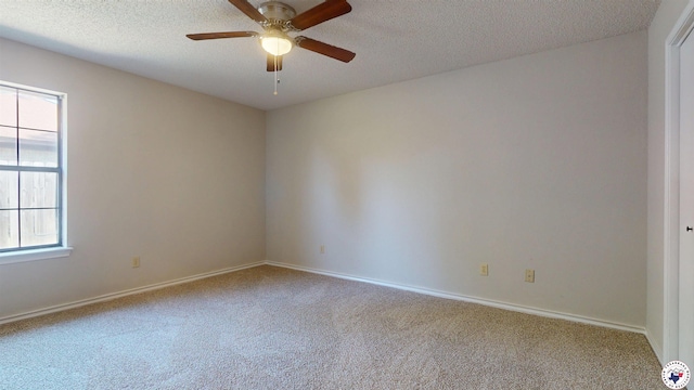 carpeted spare room featuring baseboards, a ceiling fan, and a textured ceiling