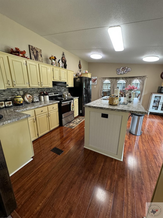 75 Westwood Ln, New Boston, TX 75570 - kitchen featuring black fridge, stainless steel range with electric stovetop, a kitchen island, light stone countertops, and backsplash