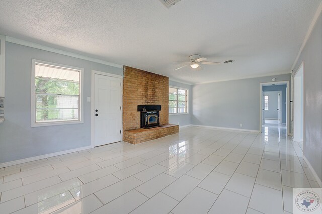 unfurnished living room with a textured ceiling, light tile patterned floors, ceiling fan, and ornamental molding