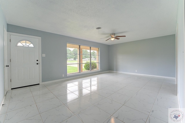 foyer entrance featuring ceiling fan and a textured ceiling