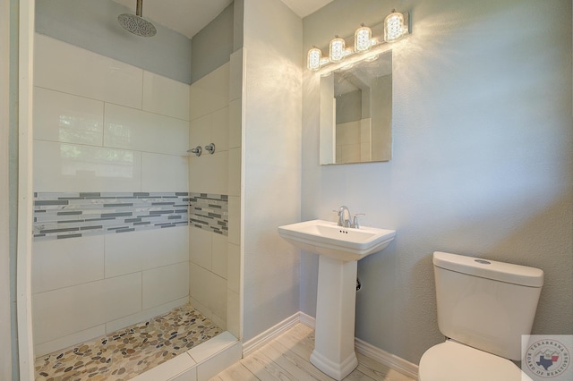 bathroom with toilet and tiled shower