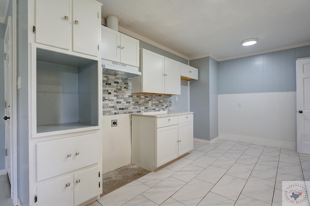 kitchen with backsplash, white cabinetry, ornamental molding, and a textured ceiling