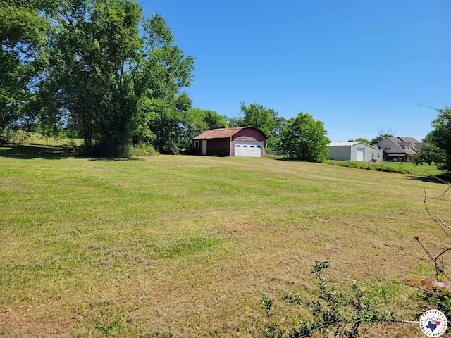 5105 Tennessee Rd, Texarkana, AR 71854 - view of grassy yard featuring a detached garage and an outbuilding
