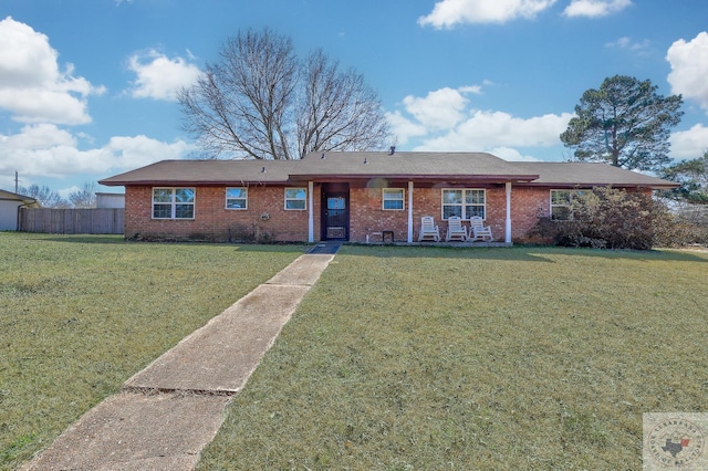 ranch-style house with brick siding, fence, and a front yard