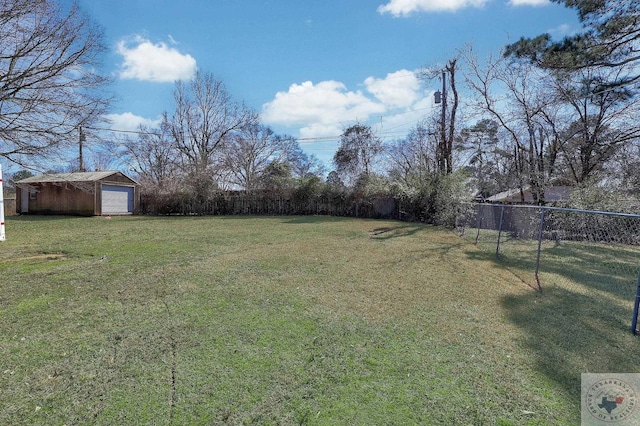 view of yard featuring a garage, fence, and an outdoor structure