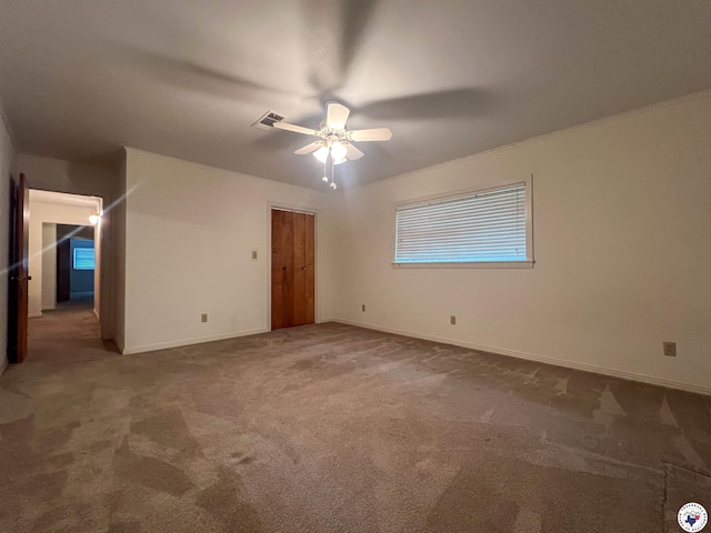 spare room featuring carpet flooring, a ceiling fan, baseboards, and visible vents