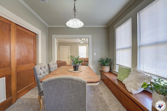 dining room featuring carpet floors, ornamental molding, a ceiling fan, and visible vents