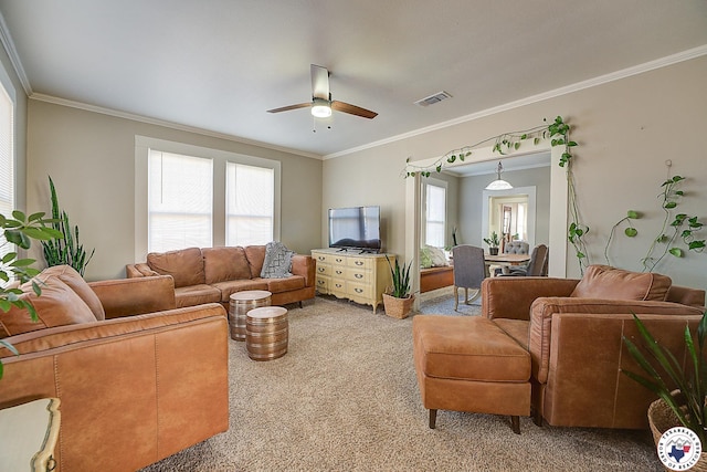 living area featuring plenty of natural light, carpet flooring, ceiling fan, and visible vents