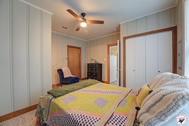 bedroom with visible vents, ornamental molding, a decorative wall, electric panel, and a ceiling fan