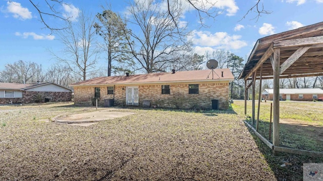 back of property featuring a lawn, central AC, french doors, brick siding, and a patio area