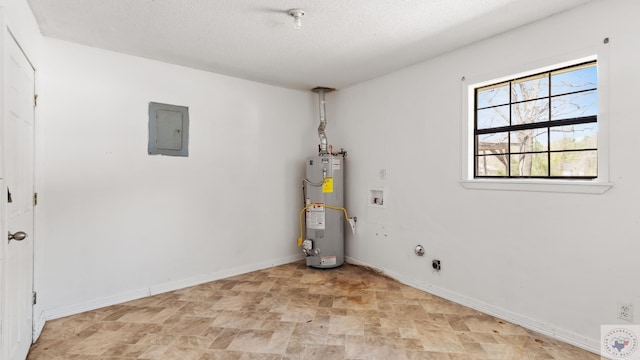 washroom with baseboards, gas water heater, washer hookup, electric panel, and laundry area