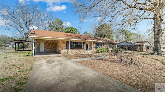single story home featuring an attached carport, brick siding, and driveway