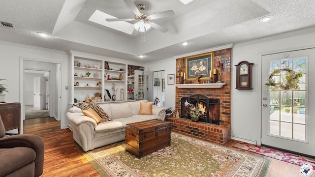 201 Larkspur Ln, Wake Village, TX 75501 - living area featuring crown molding, a ceiling fan, a skylight, wood finished floors, and a fireplace