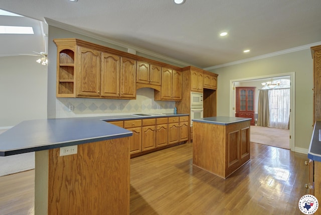 6903 Cherrybark Cir, Texarkana, AR 71854 - kitchen featuring white appliances, a peninsula, light wood-style floors, decorative backsplash, and crown molding
