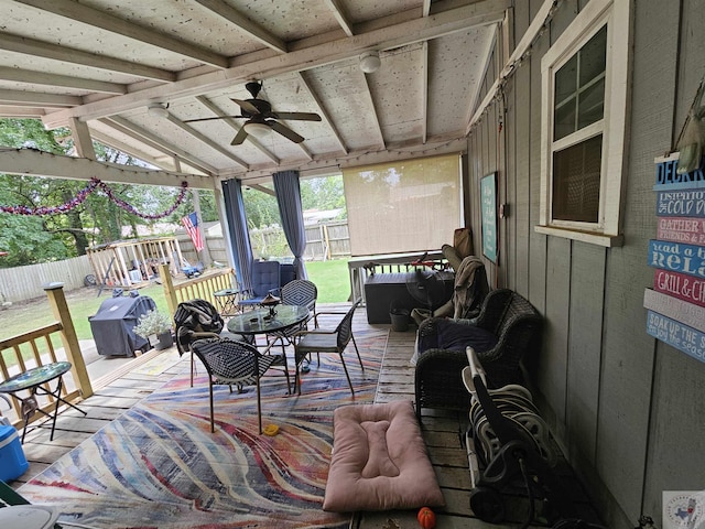 sunroom featuring ceiling fan and lofted ceiling with beams