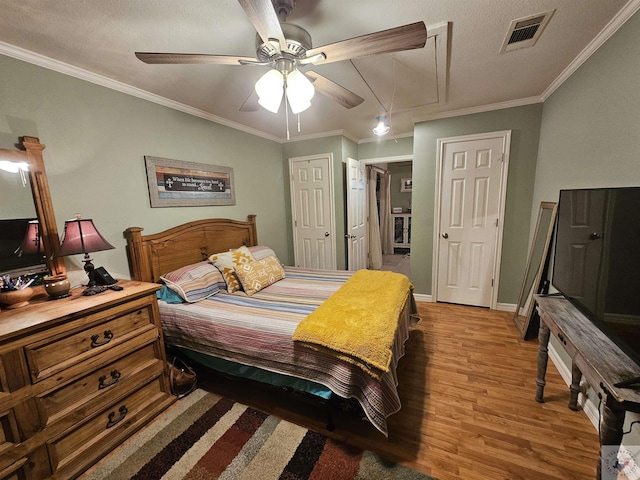 bedroom featuring light wood-type flooring, ceiling fan, ornamental molding, and a textured ceiling