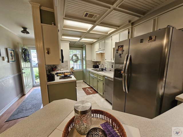 kitchen featuring green cabinets, appliances with stainless steel finishes, sink, backsplash, and coffered ceiling