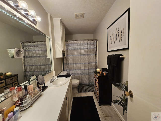 bathroom with toilet, a textured ceiling, tile patterned floors, a shower with shower curtain, and vanity