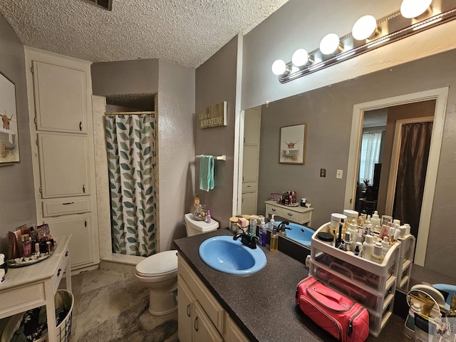 bathroom with a textured ceiling, toilet, vanity, and a shower with curtain