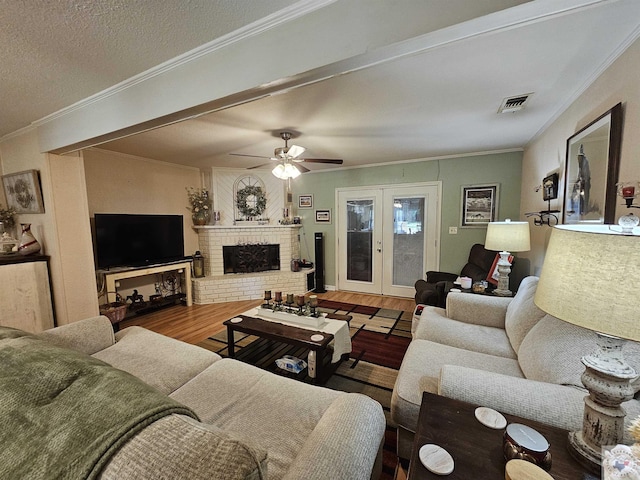 living room featuring wood-type flooring, a fireplace, and crown molding