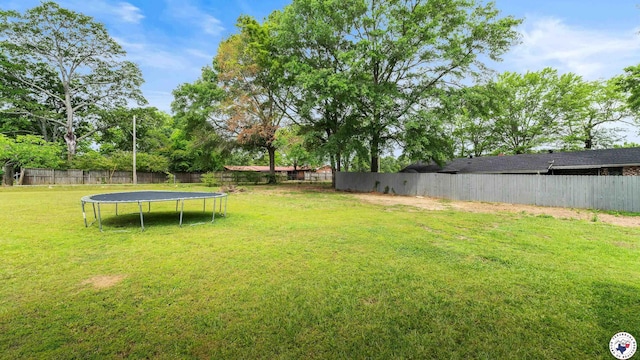 view of yard featuring a fenced backyard and a trampoline