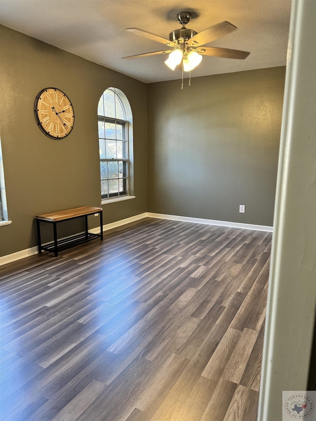 spare room featuring a textured ceiling, ceiling fan, and dark hardwood / wood-style flooring